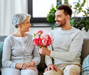 caregiver giving elder woman flowers