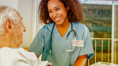 caregiver with elder man in bed